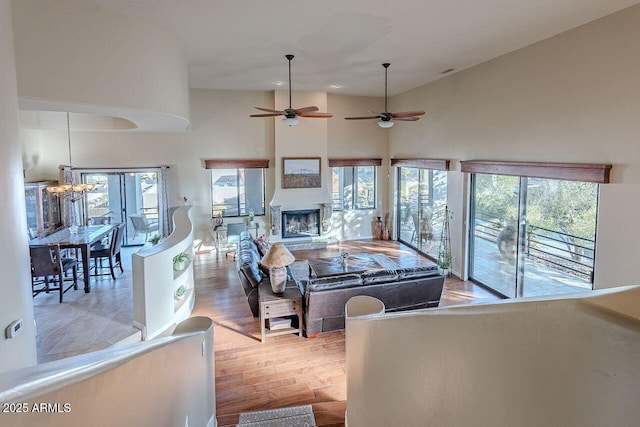 living room featuring an inviting chandelier, a towering ceiling, and light hardwood / wood-style floors