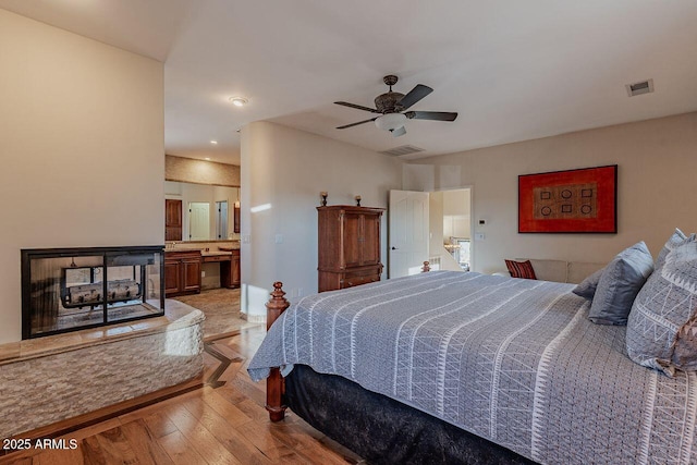 bedroom with ensuite bathroom and light hardwood / wood-style floors