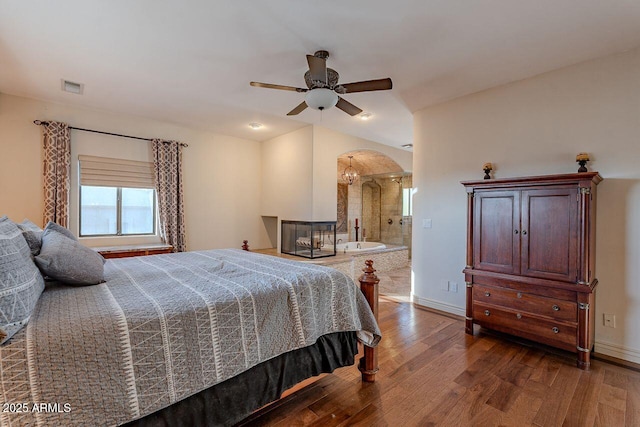 bedroom featuring dark hardwood / wood-style floors, ceiling fan, and ensuite bathroom