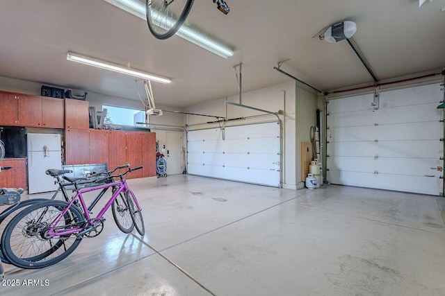 garage with white refrigerator and a garage door opener