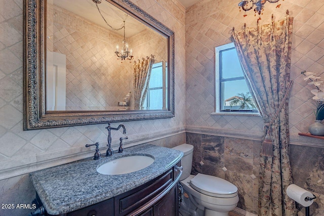 bathroom featuring vanity, tile walls, a notable chandelier, and toilet