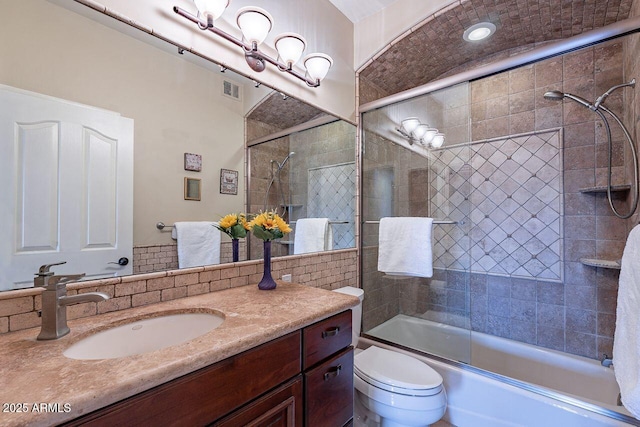 full bathroom with vanity, toilet, and combined bath / shower with glass door