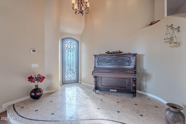 tiled foyer with a chandelier and a high ceiling