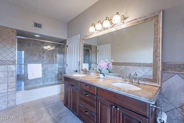 bathroom featuring vanity, tile patterned flooring, enclosed tub / shower combo, and tile walls