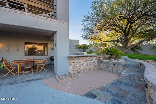 view of patio / terrace featuring a balcony and exterior kitchen