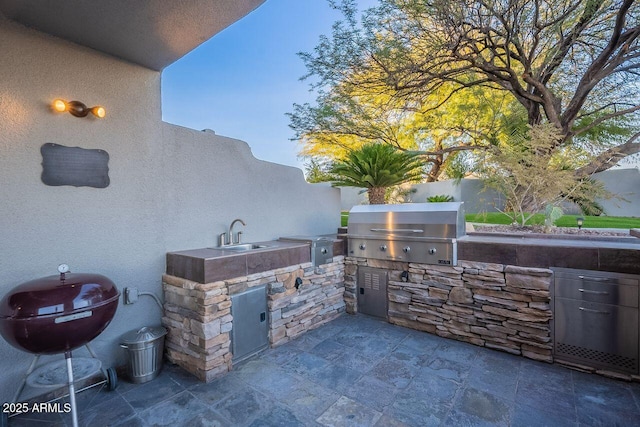 view of patio / terrace featuring area for grilling, sink, and exterior kitchen