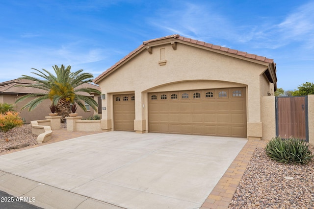 mediterranean / spanish house with stucco siding, a garage, concrete driveway, and a tile roof