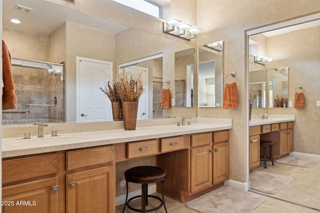 bathroom featuring visible vents, double vanity, a stall shower, tile patterned floors, and a sink