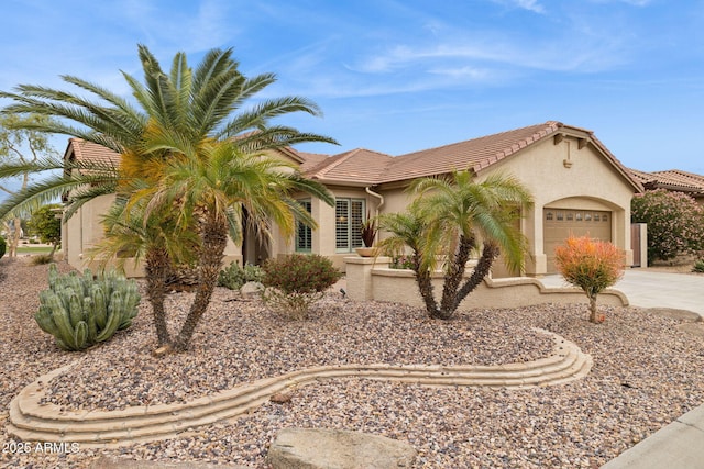 view of front of house with stucco siding, a garage, concrete driveway, and a tiled roof