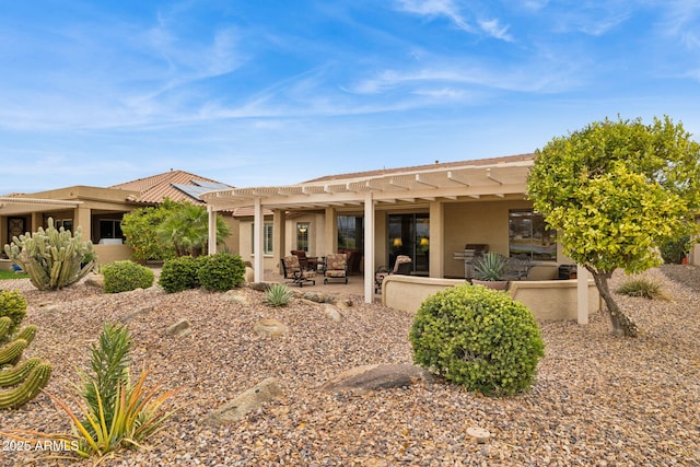 back of property featuring a patio area, a pergola, and stucco siding