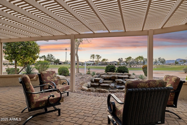 patio terrace at dusk featuring a pergola