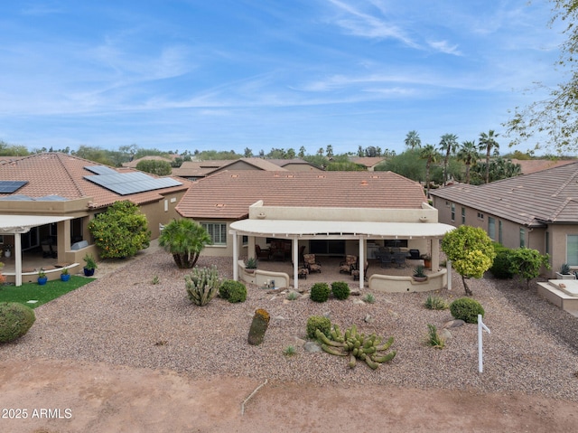 rear view of property featuring a patio area, stucco siding, and a tile roof