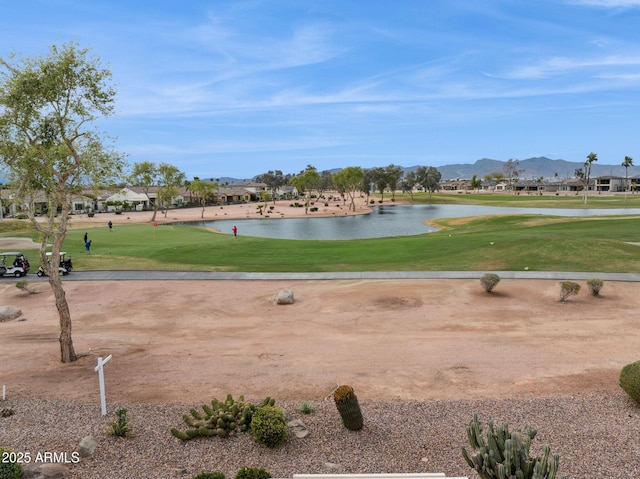 view of community featuring a water and mountain view, golf course view, and a yard