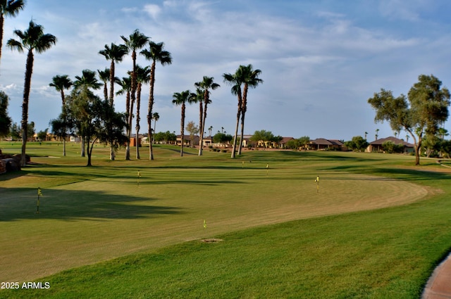 surrounding community featuring view of golf course and a yard