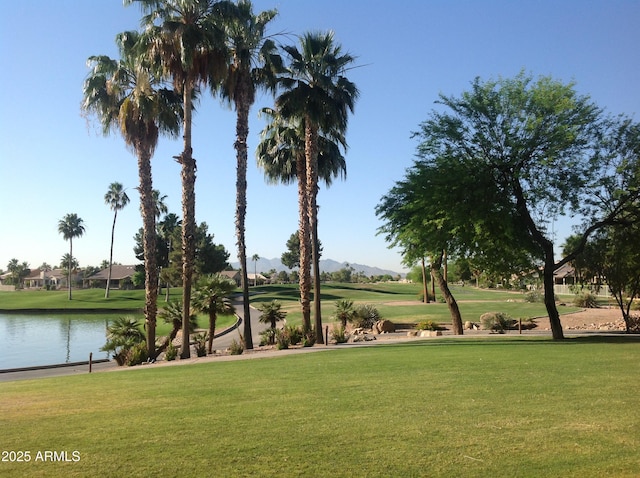 surrounding community featuring a lawn and a water view