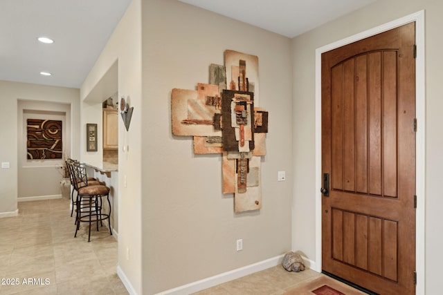 foyer with recessed lighting and baseboards