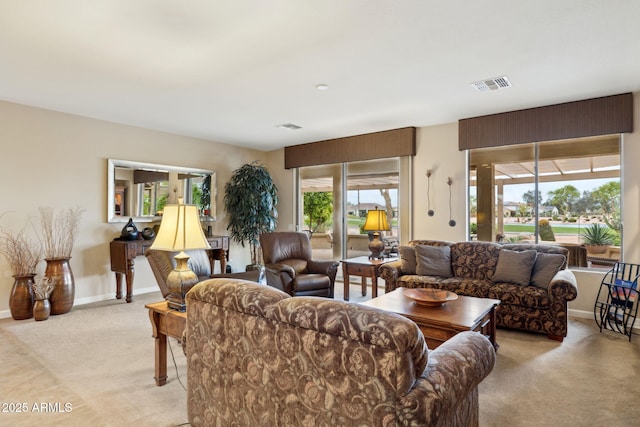 living area with baseboards, visible vents, and light carpet