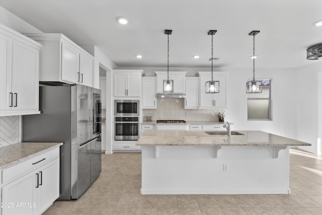 kitchen featuring stainless steel appliances, decorative light fixtures, sink, and white cabinets