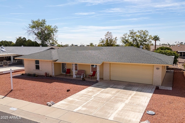 ranch-style house featuring a garage, concrete driveway, brick siding, and a shingled roof