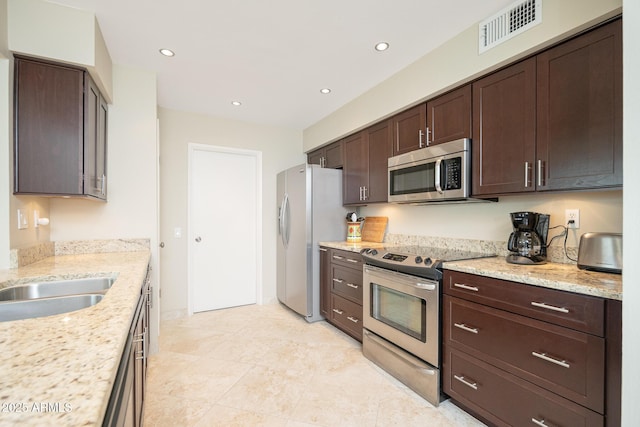 kitchen with appliances with stainless steel finishes, recessed lighting, visible vents, and light stone countertops