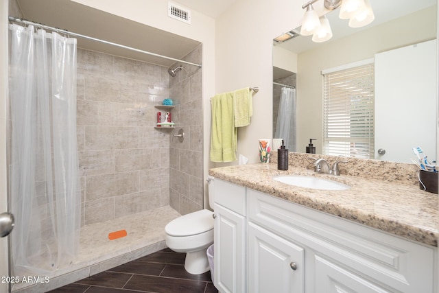 full bath with a stall shower, visible vents, vanity, and toilet