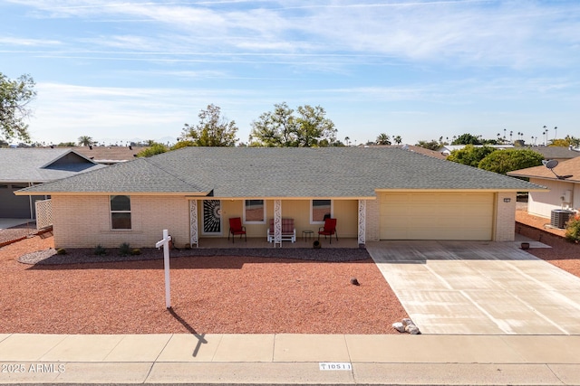 single story home featuring an attached garage, brick siding, central AC, and concrete driveway