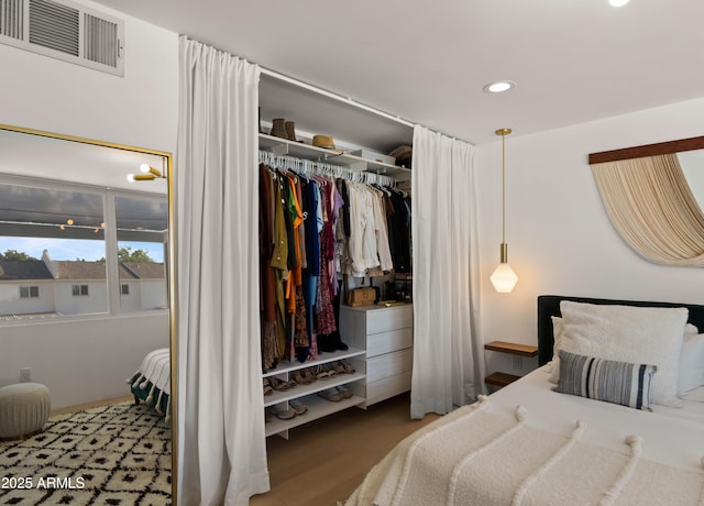 bedroom with visible vents, recessed lighting, wood finished floors, and a closet