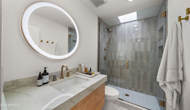 full bath featuring vanity, toilet, a skylight, visible vents, and a stall shower