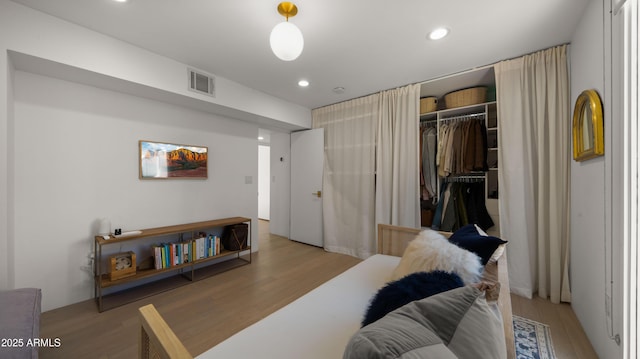 living room with recessed lighting, wood finished floors, and visible vents