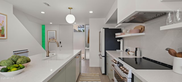 kitchen with range with electric stovetop, a sink, light countertops, and light wood-type flooring