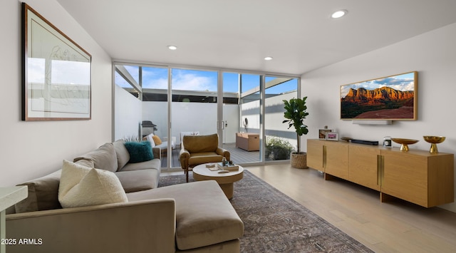 living area with recessed lighting, light wood-type flooring, and expansive windows