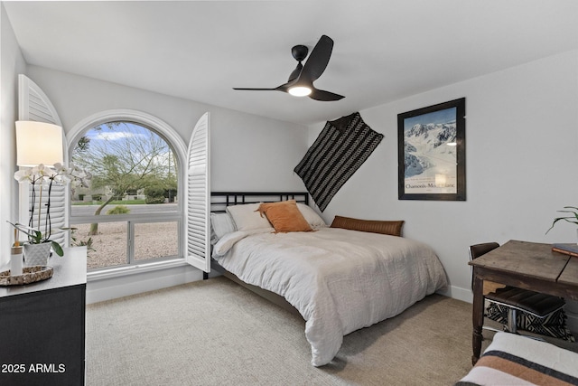 carpeted bedroom featuring baseboards and ceiling fan