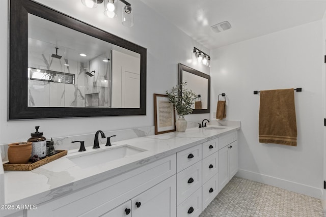 full bath featuring a sink, a marble finish shower, baseboards, and double vanity