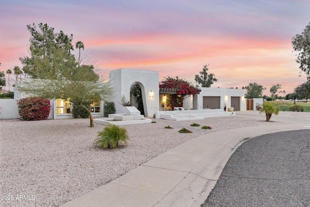 view of front of house featuring stucco siding, driveway, and a garage