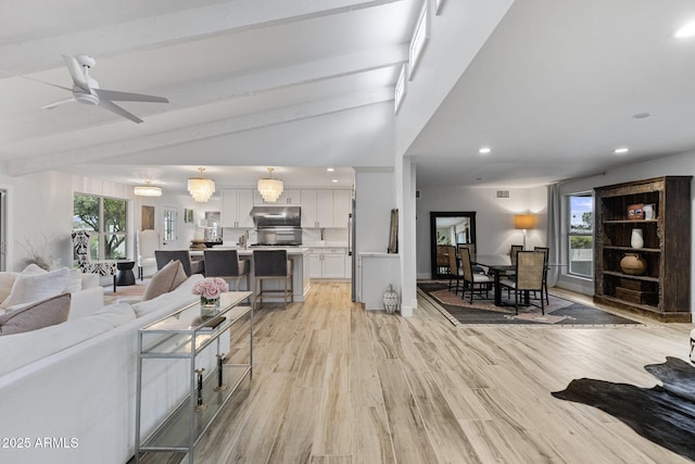 living room with visible vents, lofted ceiling with beams, recessed lighting, light wood-style flooring, and a ceiling fan