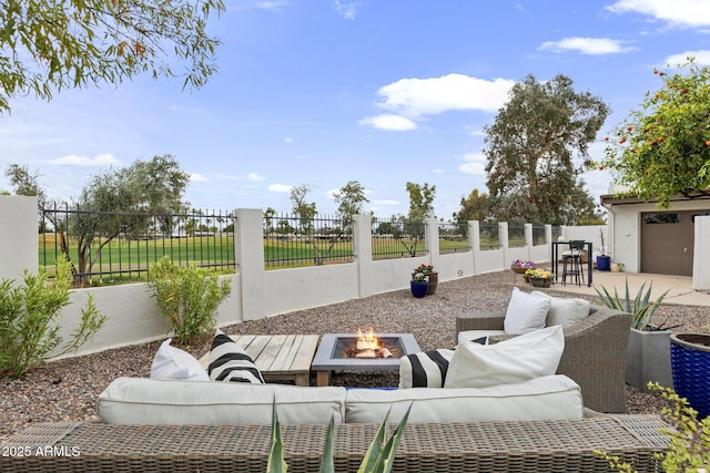 view of patio / terrace with an outdoor living space with a fire pit and a fenced backyard