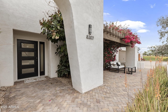 view of exterior entry with stucco siding