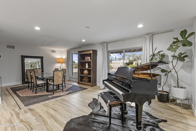 living area with visible vents, recessed lighting, and wood finished floors