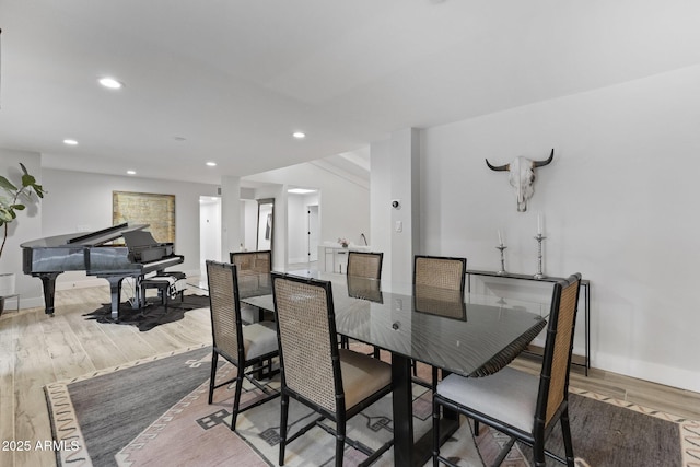 dining room featuring light wood finished floors, recessed lighting, and baseboards