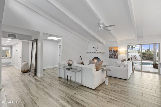 living area with baseboards, visible vents, light wood finished floors, lofted ceiling with beams, and ceiling fan