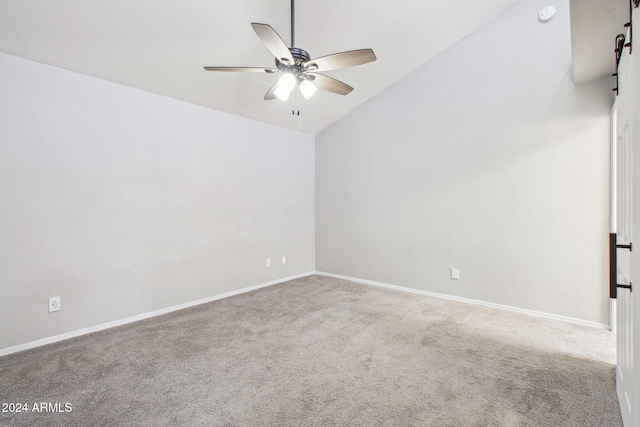 carpeted spare room featuring ceiling fan and vaulted ceiling