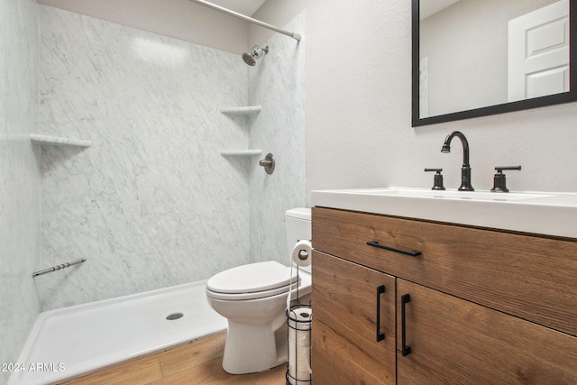 bathroom with toilet, vanity, and walk in shower