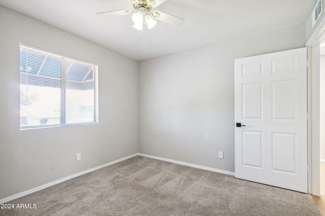 unfurnished room featuring ceiling fan and light carpet