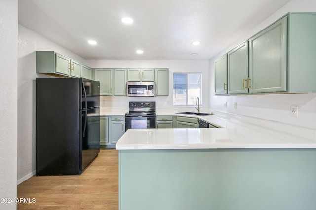 kitchen with kitchen peninsula, sink, green cabinets, and black appliances