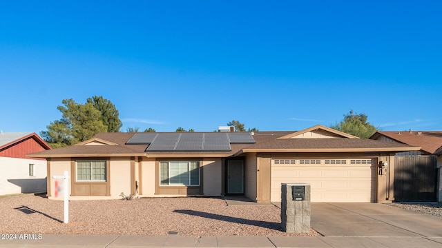 ranch-style house with a garage and solar panels