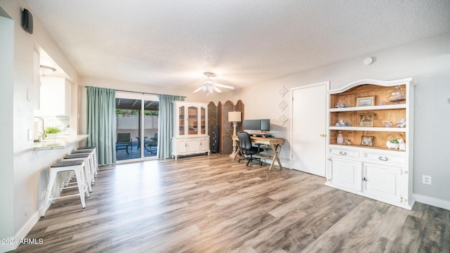 office area with hardwood / wood-style flooring, ceiling fan, and a textured ceiling