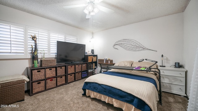 bedroom featuring ceiling fan, carpet, and a textured ceiling