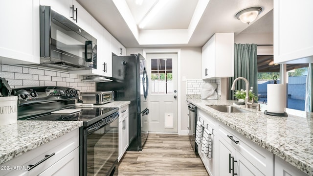 kitchen with white cabinets, sink, a wealth of natural light, and black appliances