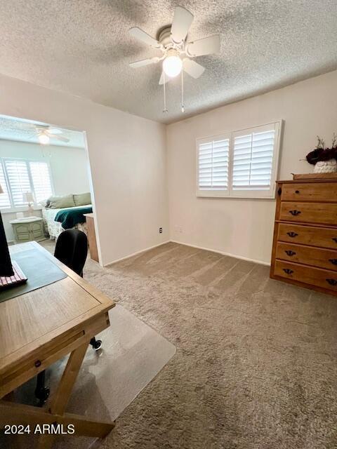 office with ceiling fan, carpet, and a textured ceiling