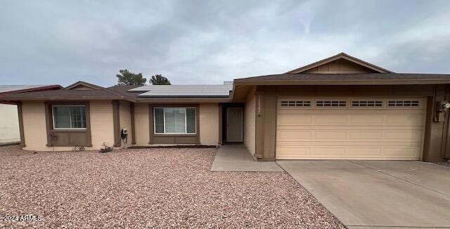 view of front of property featuring solar panels and a garage